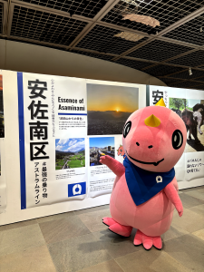 安佐南区紹介パネルの前でポーズをとるあみゴン