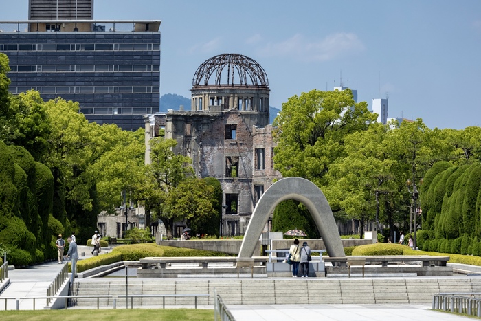 原爆ドームと慰霊碑の前で祈りをささげる様子