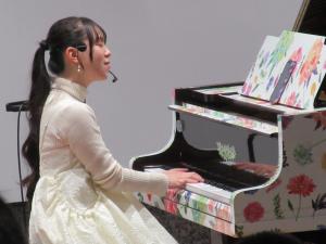 写真：ピアノを弾いてパフォーマンスするまなまるさん