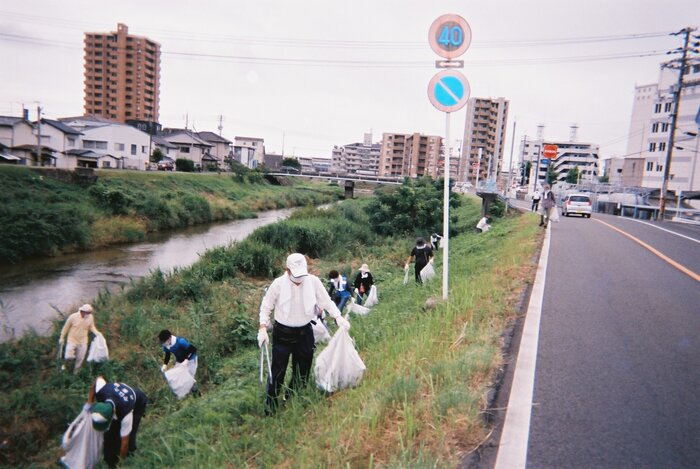 ［河川の法面を清掃する作業風景の写真］
