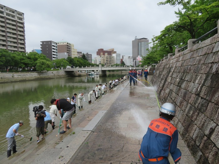 写真：消防団員が元安川の護岸清掃をしています。