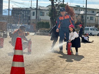 こどもが水消火器を噴射している写真
