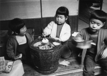 火鉢で餅を焼くこどもたち