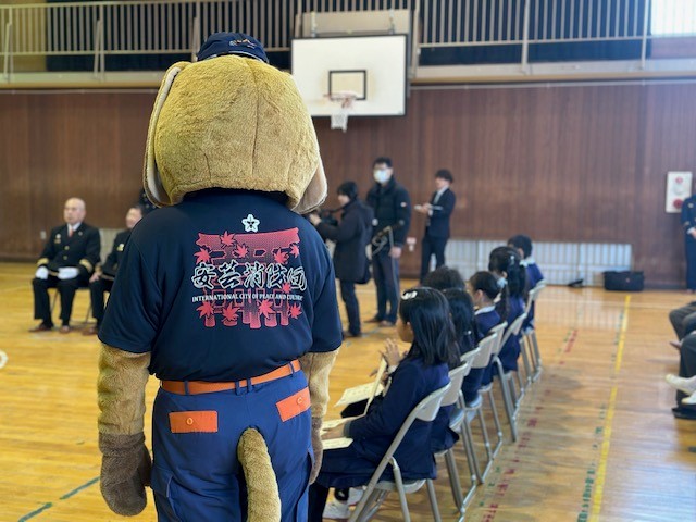 席に座ったこどもたちの後ろ姿