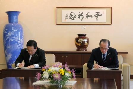 松井・横山両市長による協定書への署名の画像