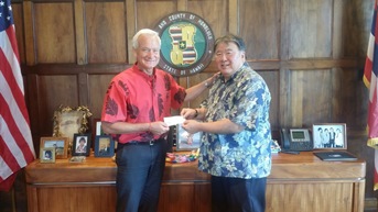 The picture of Honolulu Mayor Caldwell handing the donation to Mr. Miyao as the first contributor