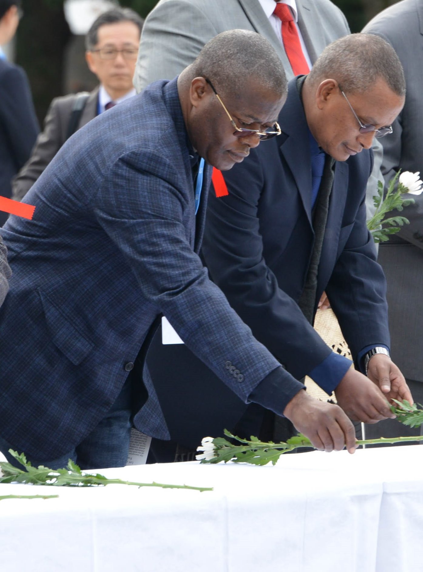 Ethiopian minister (left) and Tonga minister offering flowers at the cenotaph