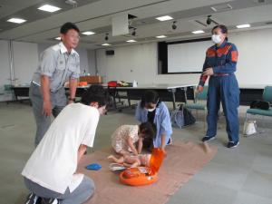 消防職員、団員、参加者、子どもが救命の練習をしている様子