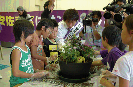 子どもたちと花を寄せ植えする佐藤選手
