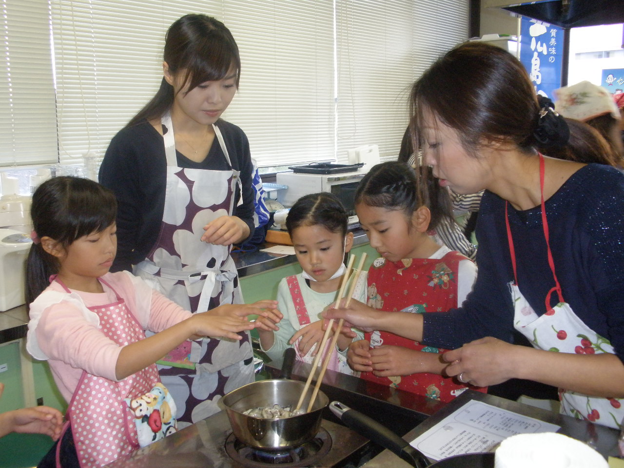 料理教室で一緒に調理する親子の写真